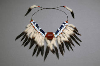 Blue and white beaded necklace with hanging fur tails on brown cord
