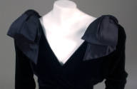 Detail of black velvet V-neck bodice with large satin shoulder bows
