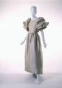 Beige satin ankle length dress with large puffed draped sleeves to elbow, gathered waist