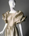 Detail of beige satin dress large puffed draped sleeves to elbow, gathered waist