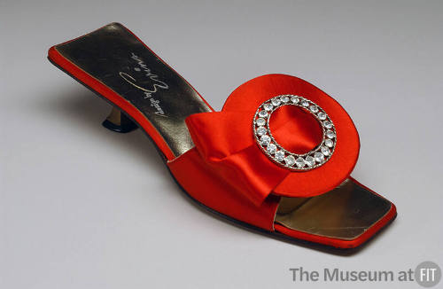 Red satin slide open toe sandal with wide front strap with circular ornament with center rhines…
