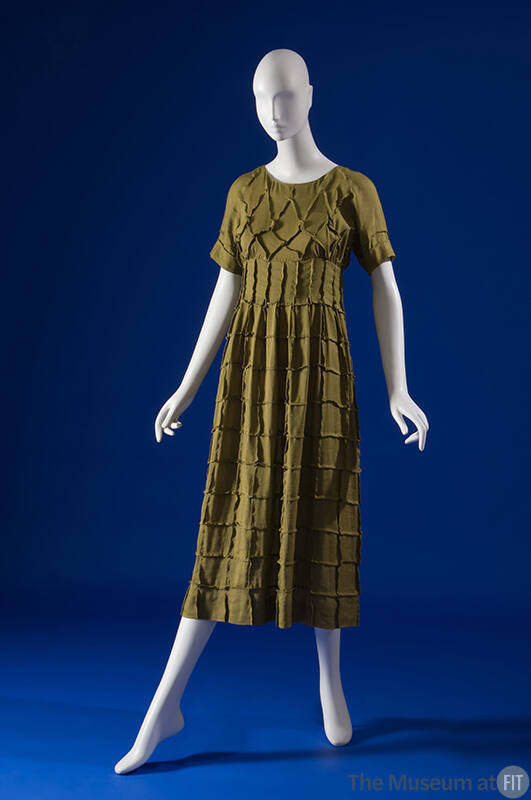 Green calf length dress with overall grid pattern, round neck, short sleeves, semi fitted