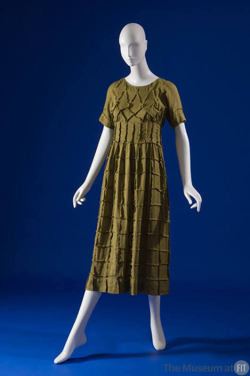 Green calf length dress with overall grid pattern, round neck, short sleeves, semi fitted