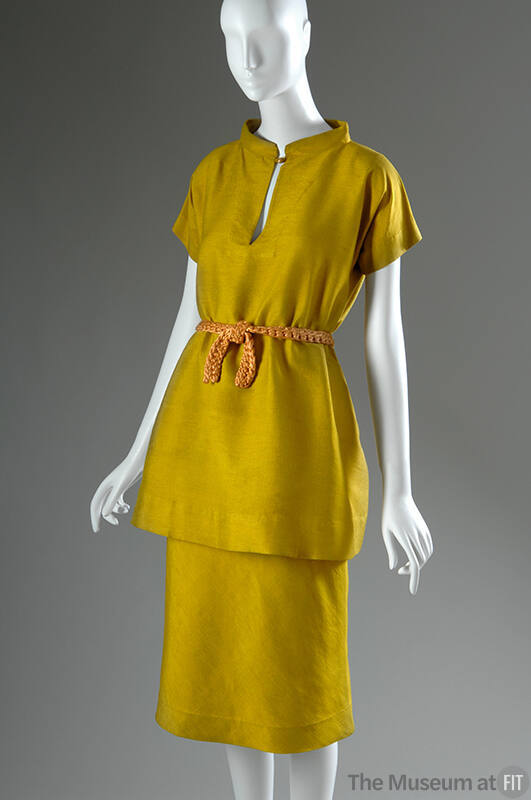 Yellow silk short sleeve tunic with gold button closure, matching below the knee straight skirt…