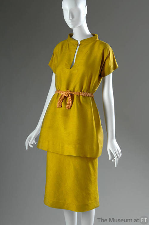 Yellow silk short sleeve tunic with gold button closure, matching below the knee straight skirt…