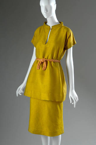 Yellow silk short sleeve tunic with gold button closure, matching below the knee straight skirt…