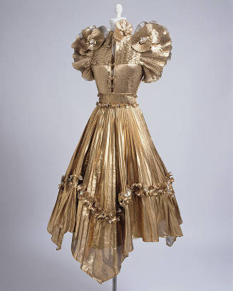 Gold lamé dress with vest bodice with ruffled pleated short sleeves and pleated skirt with asym…