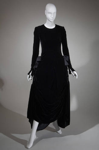 Long sleeve black velvet ankle length dress with large bows at gathered side hips