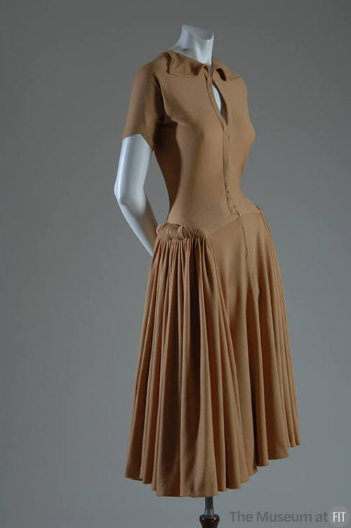 Light brown short sleeve knee length dress with small collar, pleated skirt and hip rolls