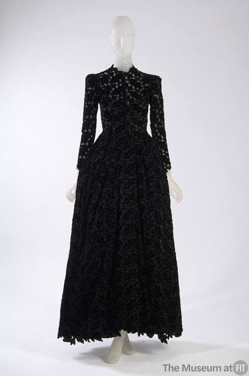 Black velvet floor length long sleeve dress with allover leaf cutouts 