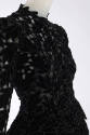 Detail of black velvet dress bodice front with leaf cutouts 