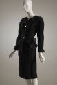 Black wool jacket with gold button front, patch pockets and bow at hip and matching skirt