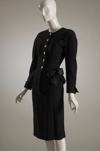 Black wool jacket with gold button front, patch pockets and bow at hip and matching skirt
