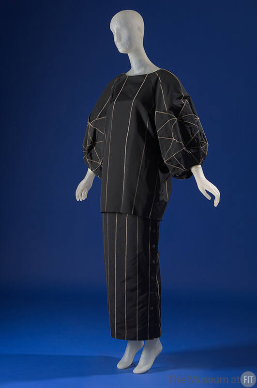 Black tunic top with long balloon sleeves, floor length skirt, both with grey topstitch details…