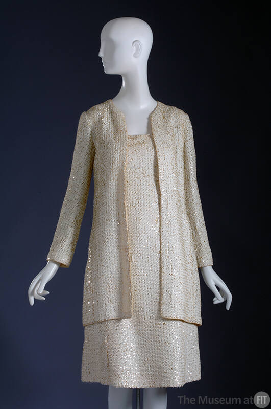 White sequinned long sleeve jacket and below-the-knee dress
