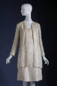 White sequinned long sleeve jacket and below-the-knee dress