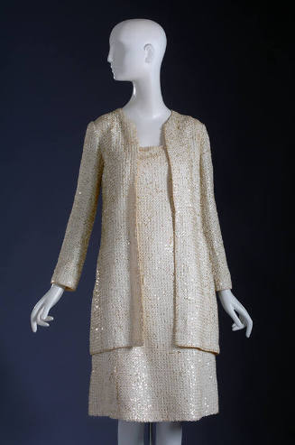 White sequinned long sleeve jacket and below-the-knee dress