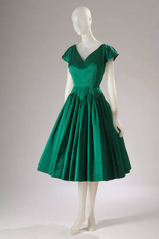 Green knee length cocktail dress with v-neck, cap sleeves and full, pleated skirt with zigzag s…