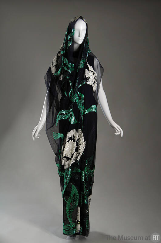 Dark blue floor length sari with sequined design of large white flowers and green leaves throug…