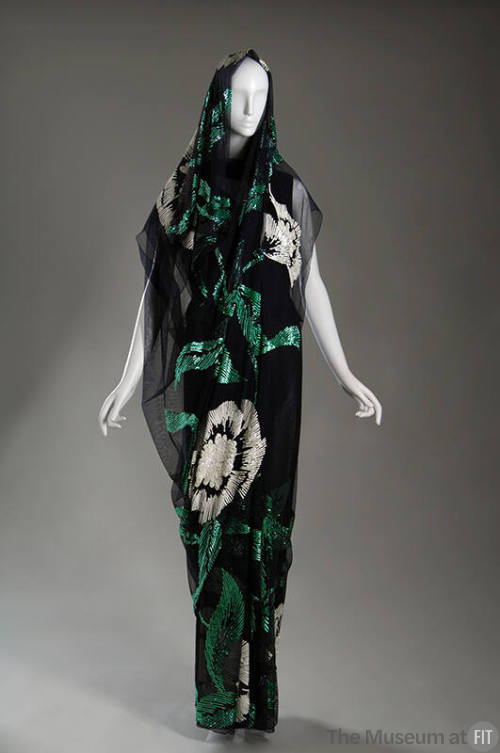 Dark blue floor length sari with sequined design of large white flowers and green leaves throug…