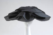 Large semicircular hat in black silk gazar with oversized petals for brim