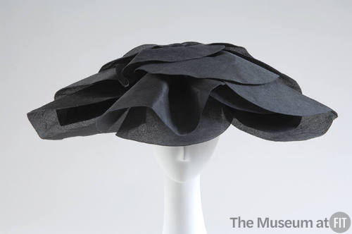 Large semicircular hat in black silk gazar with oversized petals for brim