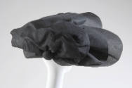 Large semicircular hat in black silk gazar with oversized petals for brim