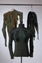 Three hanging long sleeve sweaters in shades of green and black made from socks