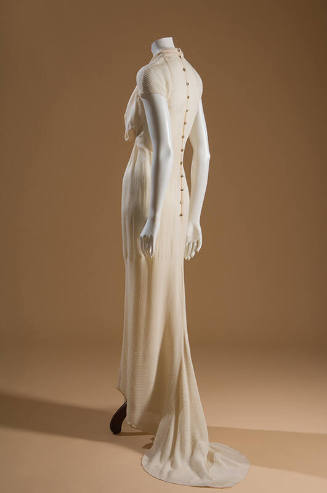 Back view: off white floor length dress, straight skirt with fishtail, and buttons down the bac…