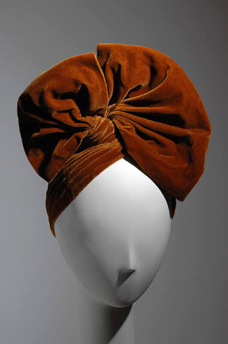 Gold velvet turban, draped into large bow shaped topknot