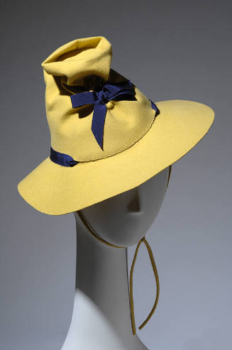 Yellow-green, conical, wide-brimmed hat with violet ribbon band and bow