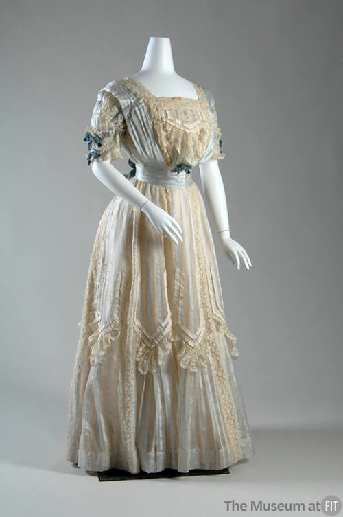 Two-piece, full length white gauze dress with lace and pale blue ribbon stripes and panels