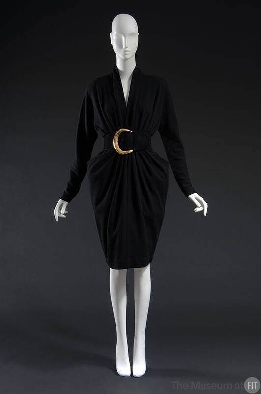 Black long sleeved dress with curved blck belt and large gold buckle