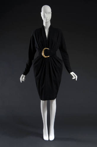 Black long sleeved dress with curved blck belt and large gold buckle