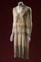 Off-white evening chemise with rhinestone bowknot bands along deep v-neck, wide rhinestone hem …