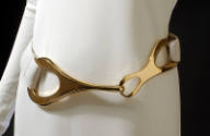 Detail view of dress belt with large buckle of abstract interlocked gold metal loops