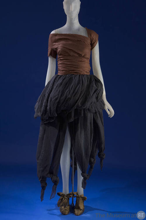 Brown sequined top with single right sleeve, black gathered pouf skirt with asymmetrical hem an…