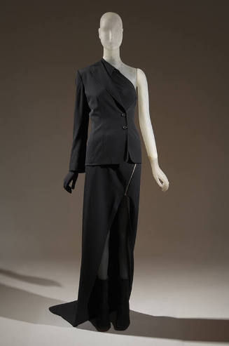 Black ensemble of suit jacket and shirt with one left arm, one left hand glove, long skirt with…