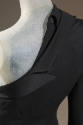 Detail view of back of black jacket showing asymmetrical jacket lapels on right side and matchi…