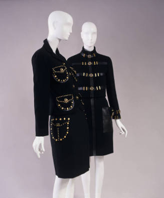 Two black suits: left with gold studs outlining large flap pockets and right with leather bands…