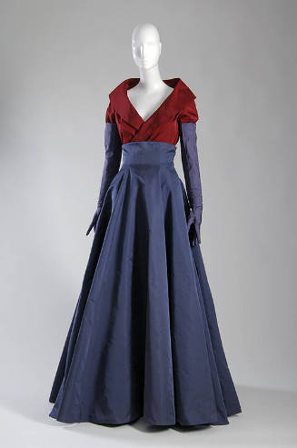 Ruby red shawl collar evening jacket with sleeves tucked into violet elbow length gloves and in…