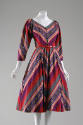 Knee length dress in varied solid and patterned stripes in purple, red, pink, gold and green, V…