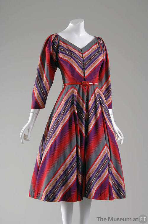 Knee length dress in varied solid and patterned stripes in purple, red, pink, gold and green, V…