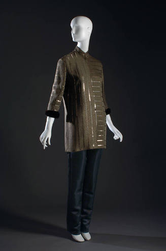 Brown tunic top with metallic stripes and brown fur cuff with black pants