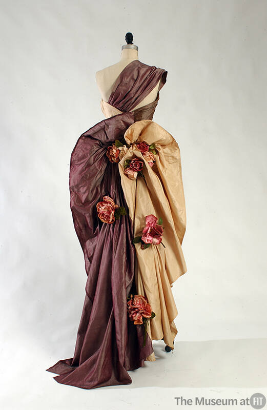 Back view of purple and taupe silk one shouder dress with silk flowers down the skirt 