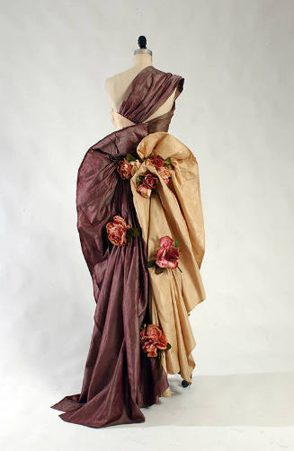 Back view of purple and taupe silk one shouder dress with silk flowers down the skirt 