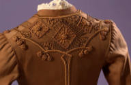 Detail of brown embroidered jacket back and lace collar