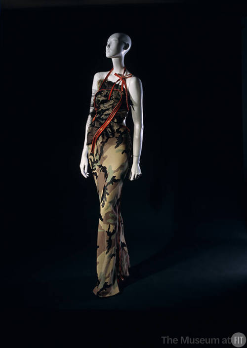 Camouflage halter evening dress with long asymmetrical and large orange plastic zippers for str…