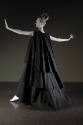 Black long sleeveless evening tent dress with three staggered full circle layers