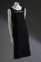 Black sleeveless pullover shift dress with bands of oval and circle cut-out slices at upper bod…